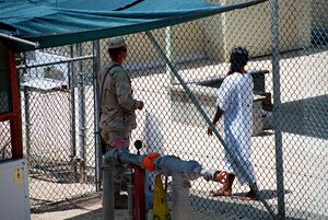 Guard talks with a captive in camp four -- the white uniform shows he is a compliant captive.jpg