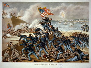 Picture of a battle with many soldiers in blue, on the right, attacking soldiers in gray uniforms in a fort on the left, with an American flag flying, and white smoke throughout.